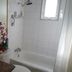 The Grateful Bed B'n'B bathroom in Prince George with bathtub, showerhead, sink and floral accents