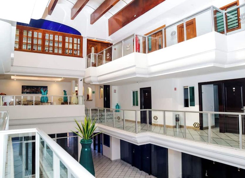 Hotel Boutique Plaza Doradas in San José del Cabo, bright atrium with upper-level walkways and white railings