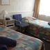 Midtown Motor Inn Whanganui room with two twin beds, bedside table, chair and window light