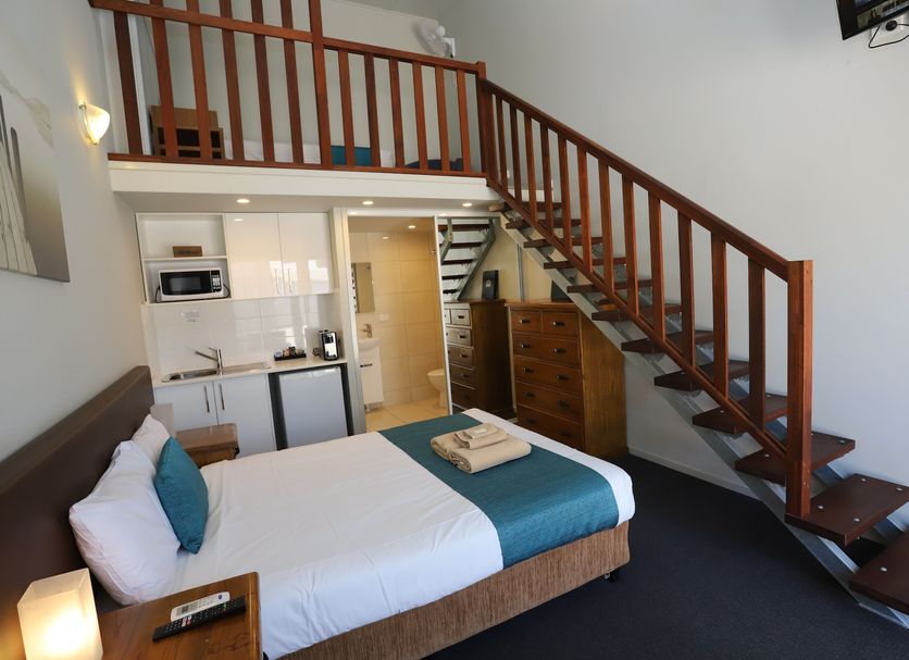 Kallangur Motel room with loft bed, staircase, kitchenette and queen bed in Kallangur