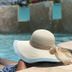 The Beach Guesthouse in La Torre: guest relaxing by an outdoor pool wearing a sun hat