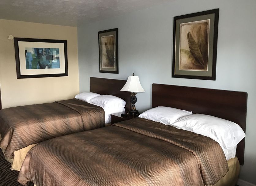 Immokalee Inn, Immokalee: double guest room with two beds, nightstand, and framed wall art