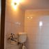 Yes Please Guest House, New Delhi bathroom with toilet, sink, wall-mounted flush tank and red bucket