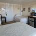 Windjammer BY The Sea in Hampton room with two beds, mini fridge, desk, and coffee maker