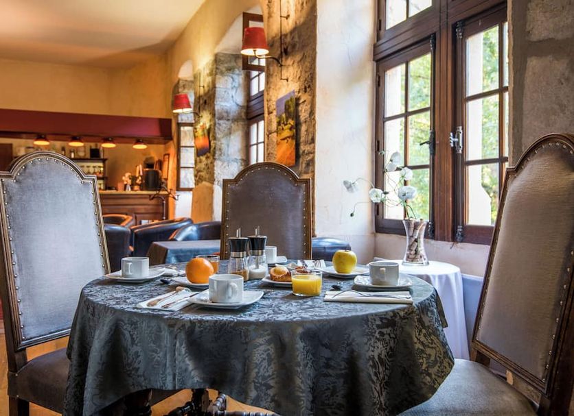 Château de la Caze in Gorges-du-Tarn-Causses, elegant dining room with set table and tall windows