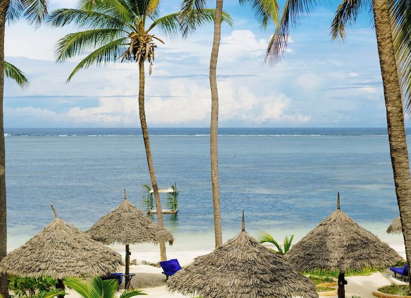 Breezes Beach Club & Spa in Zanzibar with palm trees, thatched beach umbrellas, and ocean views