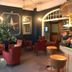 West Rocks Townhouse Eastbourne lounge with red chairs, arched windows and decorative wall art