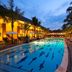 The Arnawa Hotel in Pangandaran with a lit outdoor pool and palm-lined courtyard at dusk