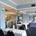 The Relais Cooden Beach dining room in Bexhill-on-Sea with set tables and a bar