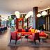 citizenM Miami World Center lobby lounge in Miami with red seating, dining tables, and modern pendant lights