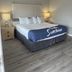 Sunglow Motel in Bicknell guest room with king bed, bedside lamps and wood-look flooring