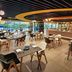 Novotel Living Saigon South in Ho Chi Minh City dining area with tables, chairs and large windows