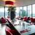Bastion Hotel Zoetermeer restaurant with red chairs and large windows overlooking Zoetermeer