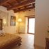 Palazzo Del Papa Agriturismo in Spoleto, rustic guest room with carved wooden bed and exposed beam ceiling