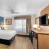 Baymont by Wyndham Arlington At Six Flags Dr room with king bed, TV, window and lamps in Arlington
