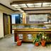 Hotel Dip Palace Darjeeling lobby front desk with wood paneling, glass counter, potted plants, and seating