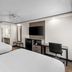 Baymont by Wyndham Arlington At Six Flags Dr guest room with two beds, desk, TV, and vanity