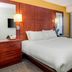 Residence Inn by Marriott Portsmouth guest room with king bed, wood panel headboard and sitting nook