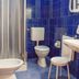Hotel Scoiattolo in Falcade bathroom with blue tile walls, shower, toilet, bidet and stool