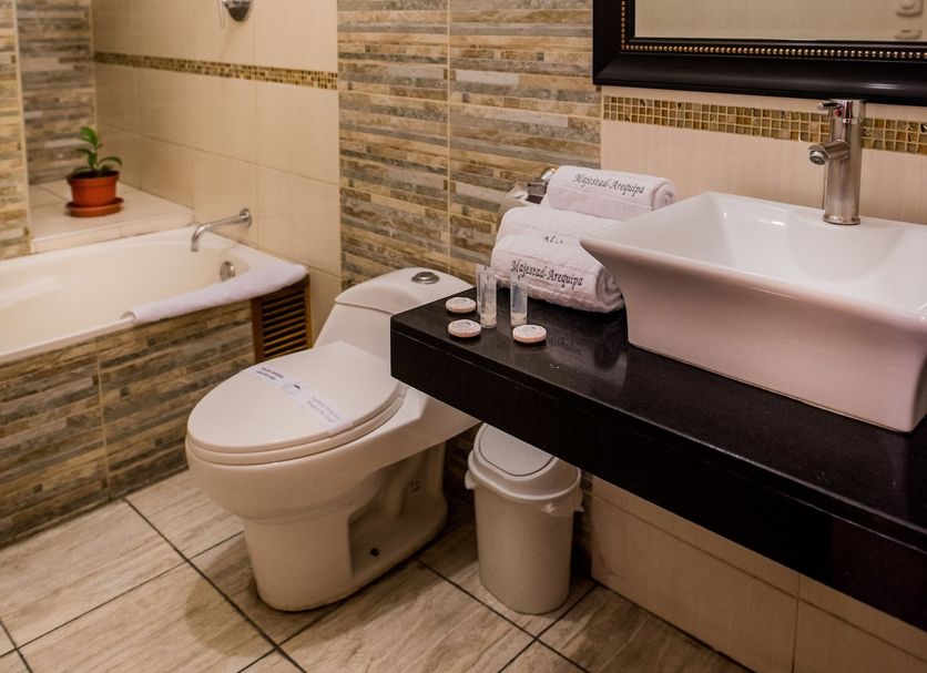 Majestad Hotel Boutique, Arequipa bathroom with tub, toilet, sink, mirror and tiled walls
