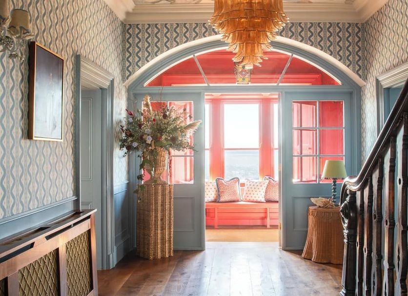 Armada House in Spanish Point hallway with arched doorway to a bright red sitting area