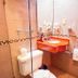 Maya Campeche Hotel bathroom with orange sink vanity, toilet, towel rack and tiled shower wall in Campeche
