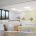 Holiday Inn Northampton By IHG wedding ceremony room with white chairs, floral arrangements and bright windows