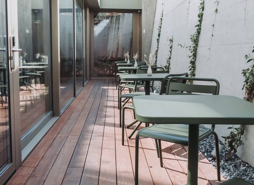 Montreux Youth Hostel in Montreux, narrow outdoor terrace with tables and chairs beside glass windows