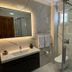 Hotel Melisa bathroom in Bozburun with marble walls, sink vanity, toilet and glass shower enclosure