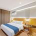 Aishangyijia Hotel in Wuhu room with double bed, blue runner, curtains and wall-mounted TV