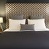 The Heritage Bendigo bedroom with patterned headboard, neatly made bed, bedside lamps and sofa