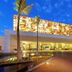 TRS Coral Hotel in Cancún exterior entrance with illuminated facade and palm trees at dusk