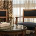 Cherry Maryski Hotel Alexandria seating area with two chairs and a small table by sheer curtains