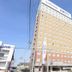 Toyoko Inn Gumma Isesaki Ekimae in Isesaki, tall tan hotel exterior with blue sky