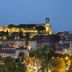 Cannes skyline at dusk with illuminated hilltop fortress and waterfront below, near Five Seas by Inwood Hotels.