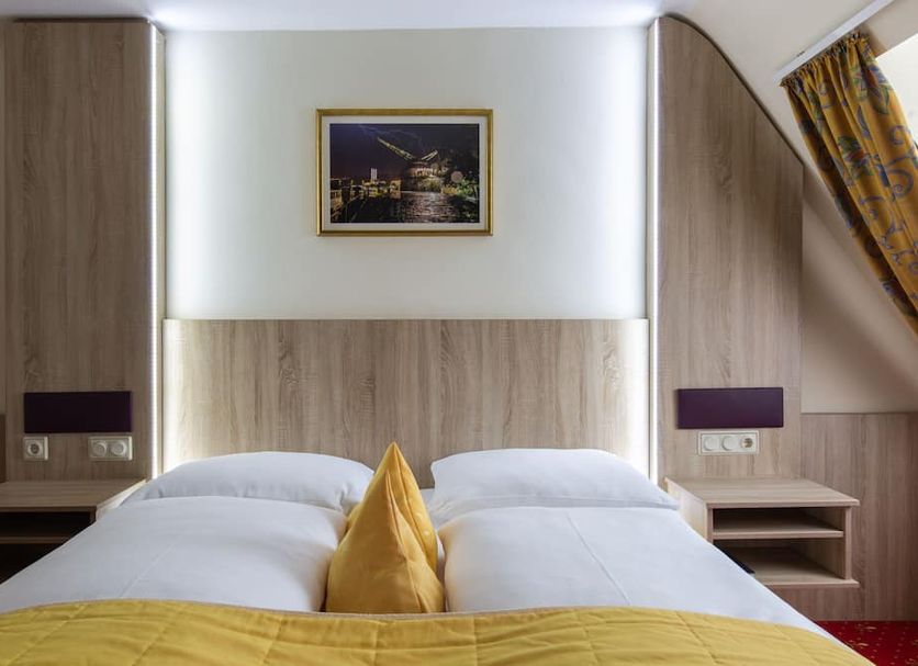 Hotel Residence Wurzburg guest room with twin beds, wood-paneled walls and framed wall art