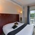Contact Hotel Le Moulin Neuf Chantonnay room with bed and balcony door overlooking greenery