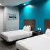 Scottish Inns & Suites - Kingwood in Humble: guest room with two beds and teal accent wall