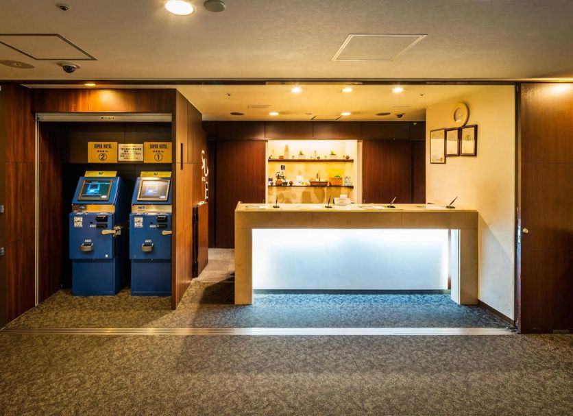 Super Hotel Inn Sendai Kokubuncho lobby with self-service check-in kiosks and illuminated front desk in Sendai