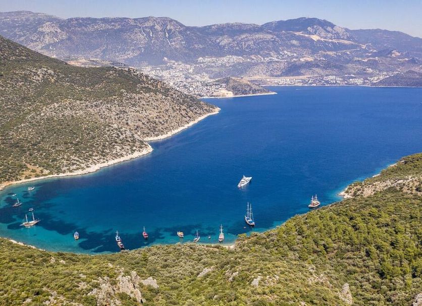 Xanthos Boutique Hotel Patara in Gelemiş overlooking a blue bay with sailboats and rocky hills