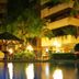 Yotau All Suites Hotel in Santa Cruz de la Sierra with a lit courtyard pool and palm trees at night