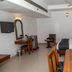 Hotel Maurya International Chennai room with bed, dining table, desk, wall-mounted TV and ceiling fan