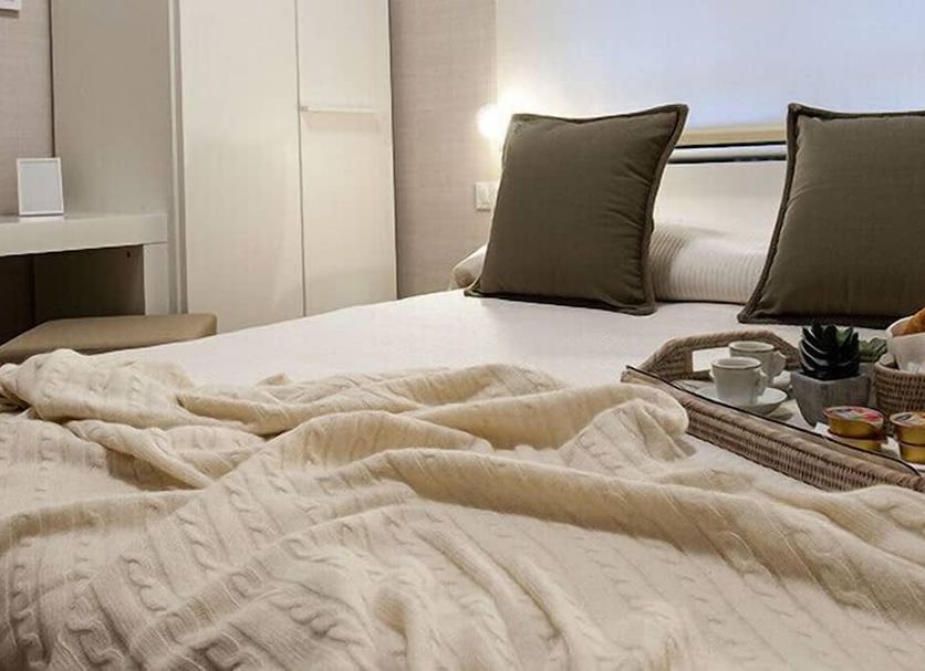 B&B Blanc Pescara guest room with neatly made bed, tray with tea service, and bedside lighting