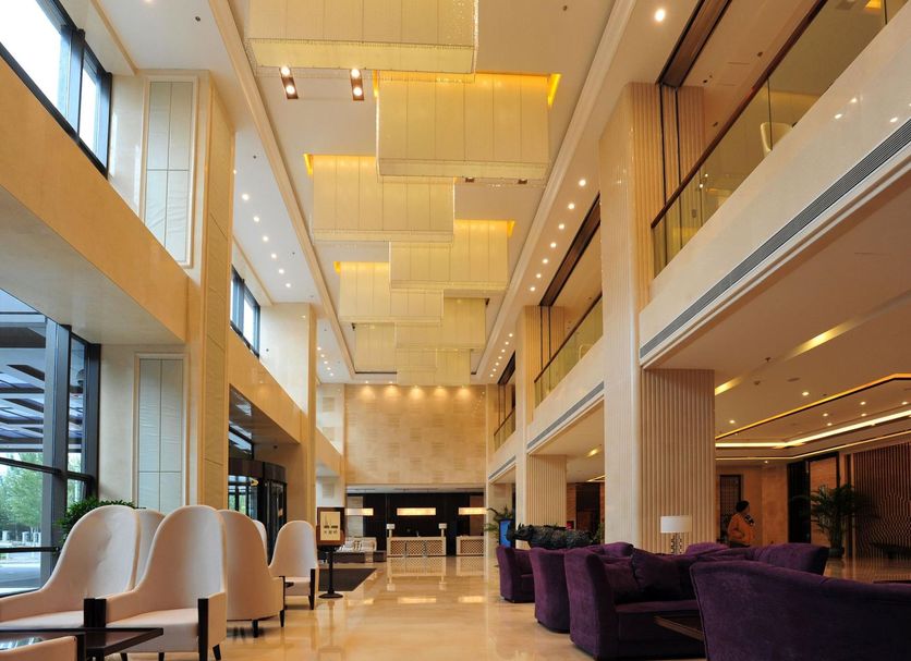 Shenyang Neu International Hotel lobby in Shenyang with tall ceilings, lounge seating, and large windows