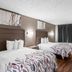Red Roof Inn Richmond - Airport Sandston guest room with two beds, wood floors, and a window with dark curtains