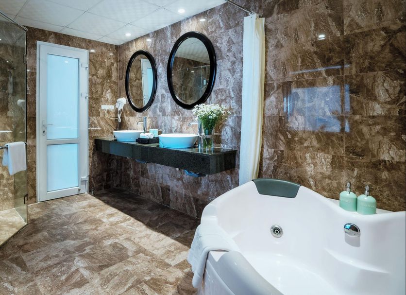 Hoian Sincerity Hotel & Spa in Hoi An bathroom with double sinks, glass shower and soaking tub