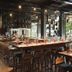 Hotel G Yangon bar and restaurant interior with long wooden counter, high stools, and large windows