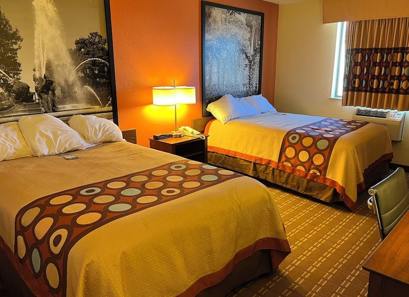 Super 8 by Wyndham Altoona room with two beds, lamp, window and patterned curtains