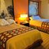 Super 8 by Wyndham Altoona room with two beds, lamp, window and patterned curtains