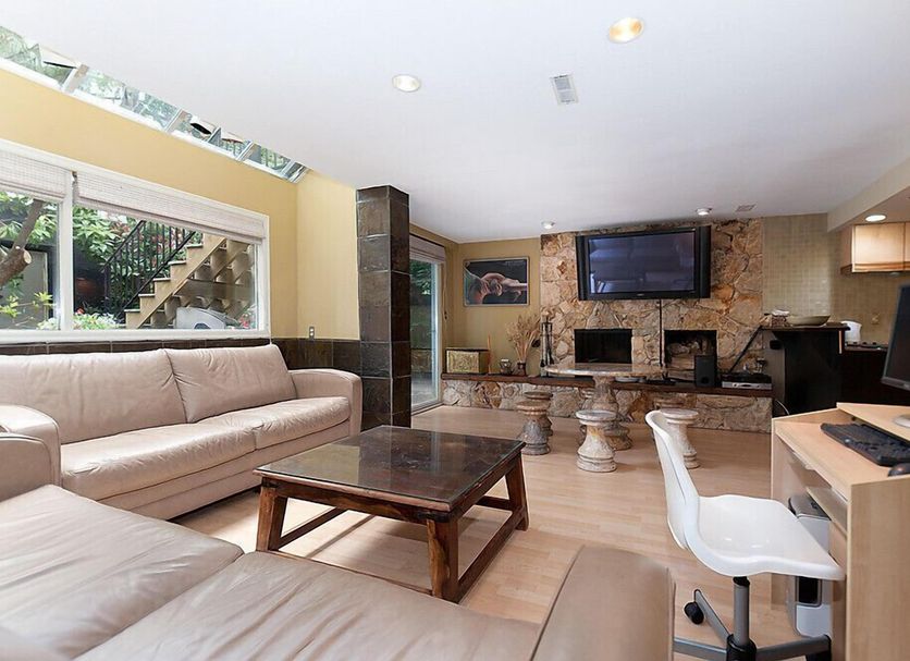House On Dunbar B&B in Vancouver living room with sectional sofa, fireplace, TV and desk